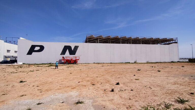 Nave industrial con el nombre de la empresa rotulado a gran tamaño en la fachada